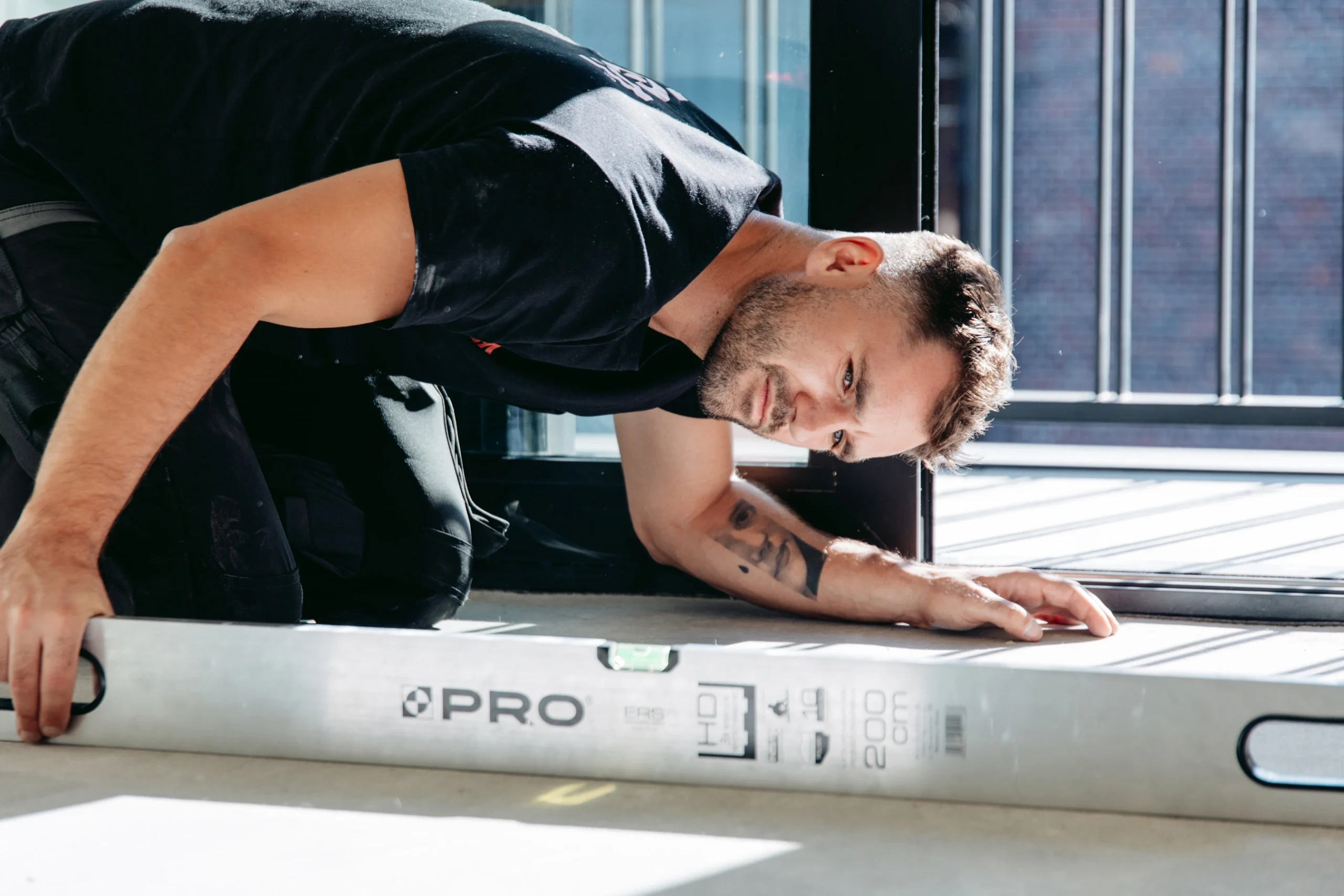 inspektor-budowlany-za-pomocą-poziomicy-sprawdza-równość-posadzki